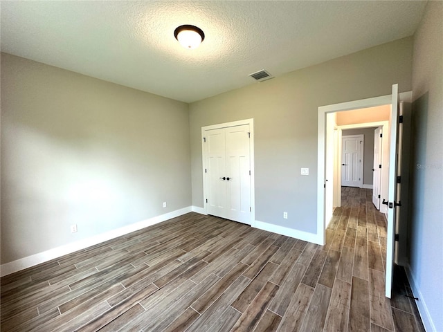 36 Armand Beach Dr, Palm Coast, FL 32137 - unfurnished bedroom featuring dark wood-style floors, a closet, and a textured ceiling