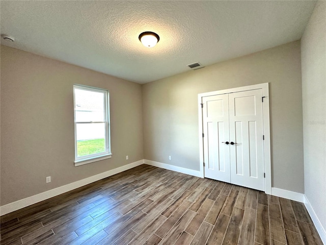 36 Armand Beach Dr, Palm Coast, FL 32137 - unfurnished bedroom with dark wood finished floors, a textured ceiling, and a closet