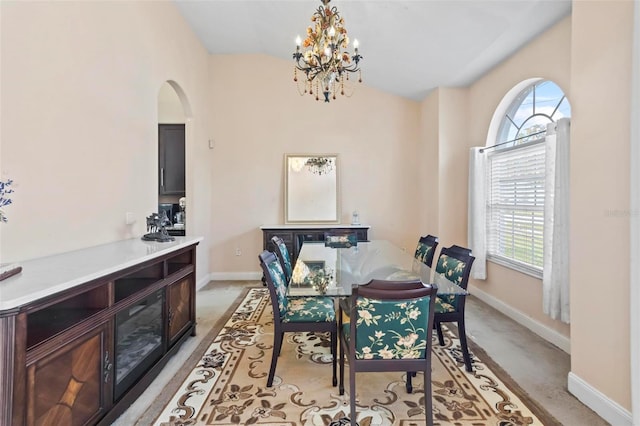 carpeted dining space featuring a notable chandelier