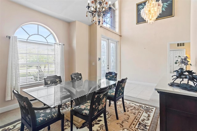 tiled dining area with a notable chandelier, a healthy amount of sunlight, and french doors