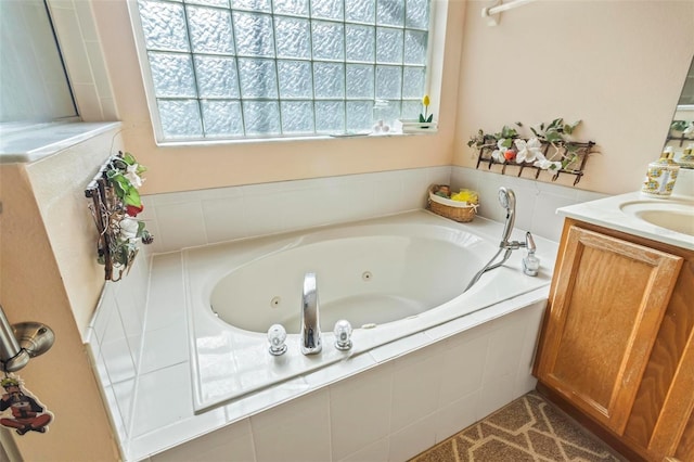 bathroom featuring tiled tub and vanity