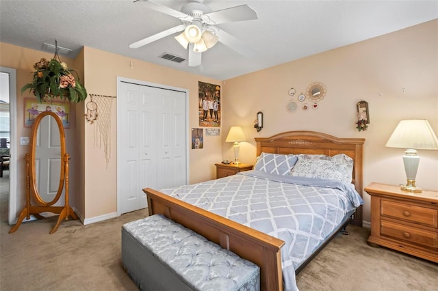 carpeted bedroom featuring ceiling fan and a closet