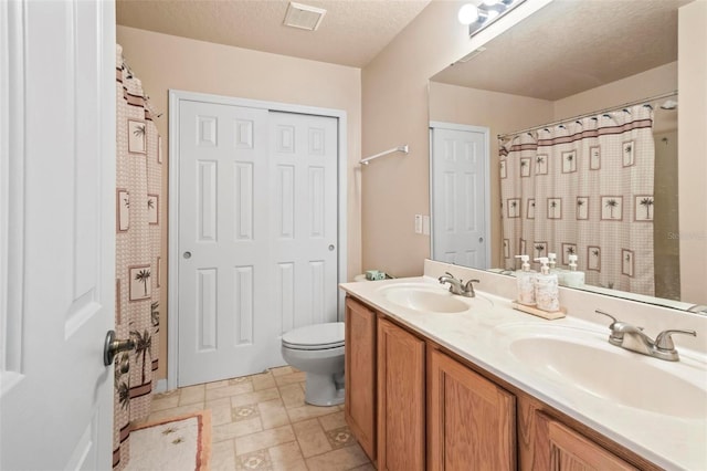 bathroom with toilet, vanity, a textured ceiling, and curtained shower