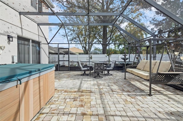 view of patio / terrace featuring a lanai and a hot tub