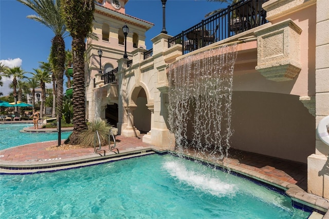 view of swimming pool with pool water feature