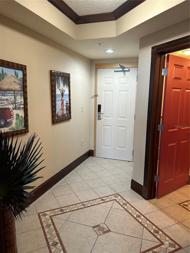 foyer entrance with light tile patterned floors and ornamental molding