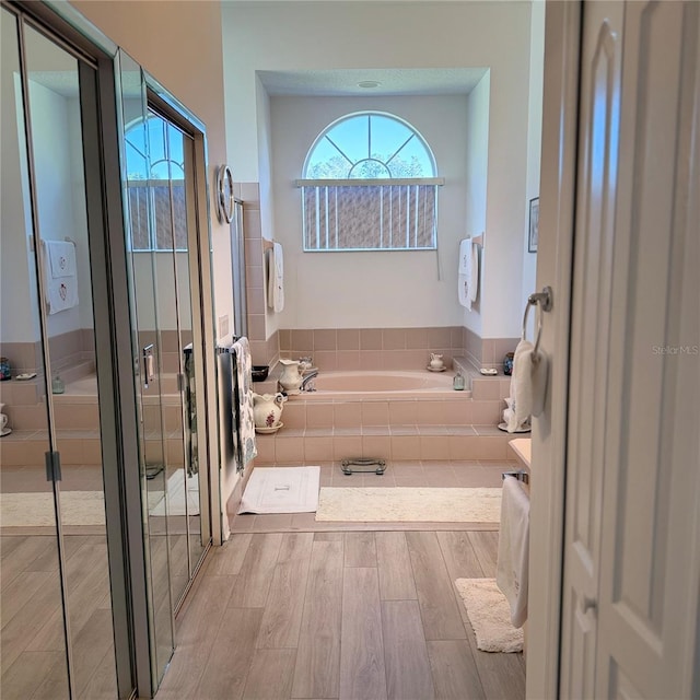 bathroom featuring hardwood / wood-style floors, independent shower and bath, and plenty of natural light