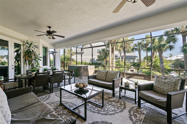 sunroom / solarium featuring ceiling fan and a water view