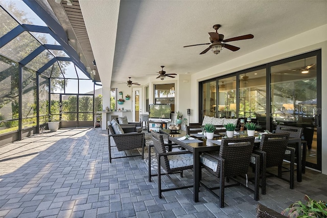 view of patio / terrace featuring glass enclosure, ceiling fan, and an outdoor hangout area