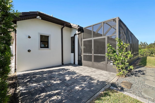 rear view of property featuring a patio area and a lanai