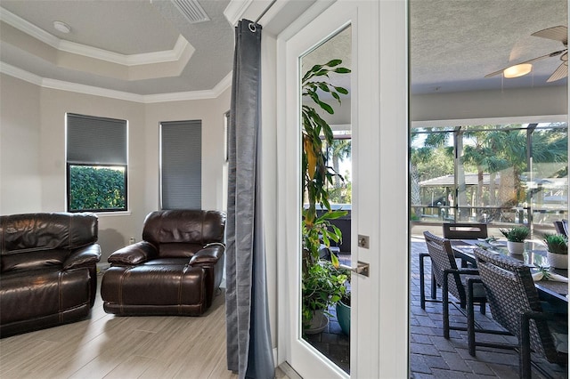 interior space with a textured ceiling, ceiling fan, light hardwood / wood-style floors, and crown molding