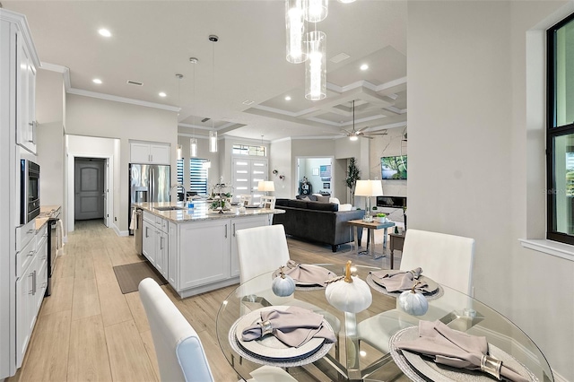 dining area with coffered ceiling, sink, light hardwood / wood-style flooring, ceiling fan, and beam ceiling