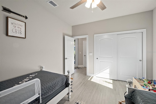 bedroom featuring ceiling fan, a closet, and light wood-type flooring