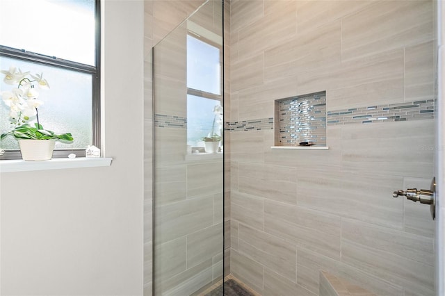 bathroom with plenty of natural light and tiled shower