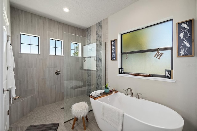 bathroom with plus walk in shower and a textured ceiling