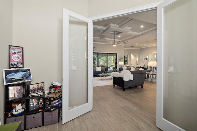 hallway featuring beam ceiling, light hardwood / wood-style flooring, coffered ceiling, and ornamental molding