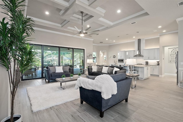 living room with ceiling fan, light wood-type flooring, crown molding, and coffered ceiling