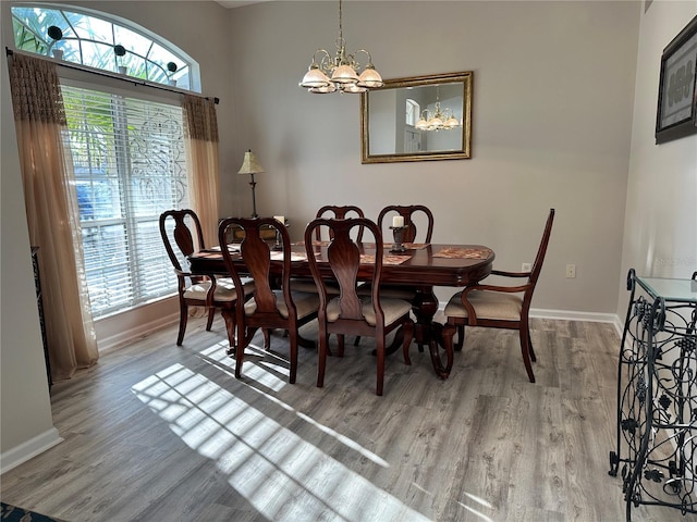 dining area with a notable chandelier, wood finished floors, and baseboards