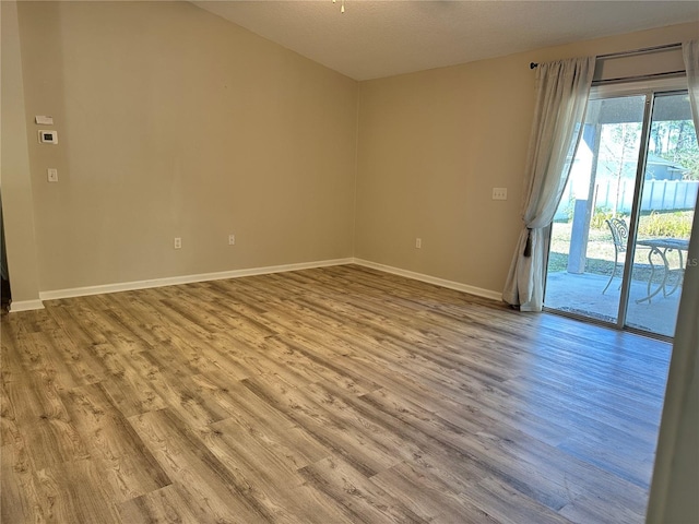 unfurnished room featuring baseboards and wood finished floors