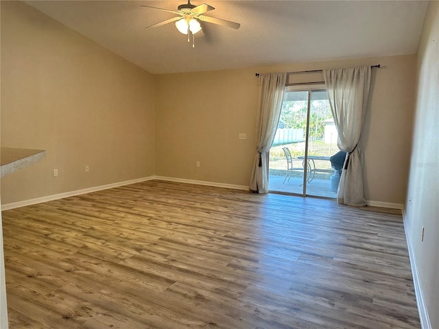 spare room with ceiling fan, baseboards, and wood finished floors