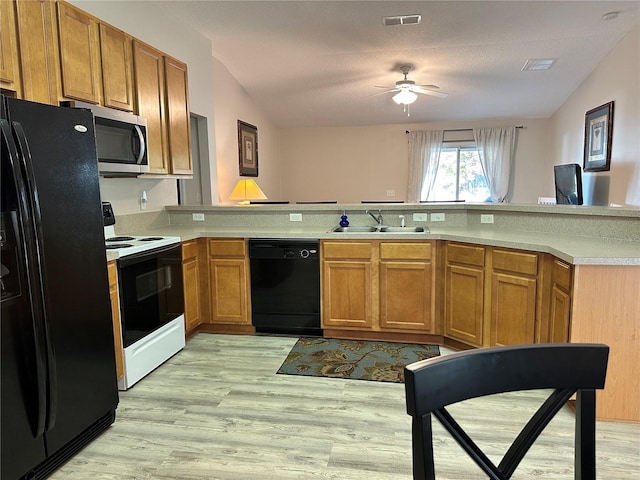 kitchen with black appliances, light wood-type flooring, visible vents, and a sink