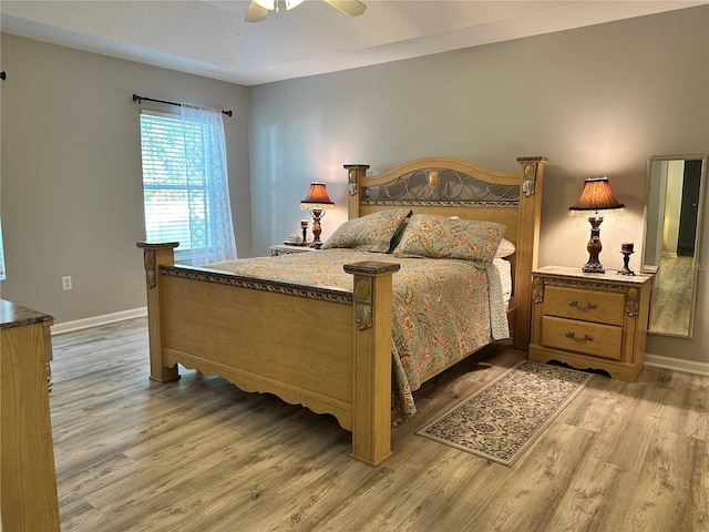 bedroom featuring baseboards, light wood-style flooring, and a ceiling fan