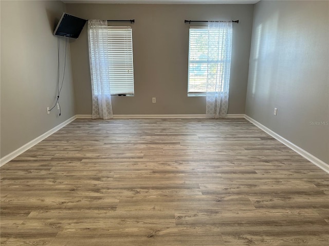 empty room with baseboards and wood finished floors