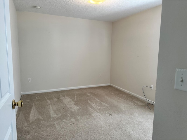 empty room featuring baseboards, carpet floors, and a textured ceiling