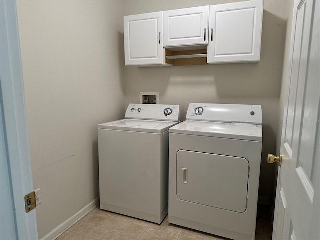 laundry area featuring cabinet space, light tile patterned floors, separate washer and dryer, and baseboards