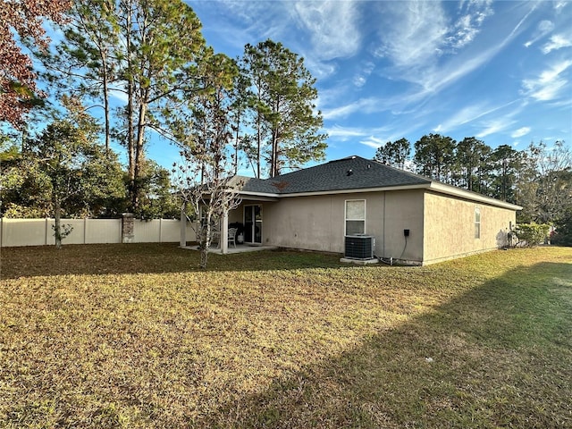 back of property with cooling unit, a fenced backyard, stucco siding, a patio area, and a lawn