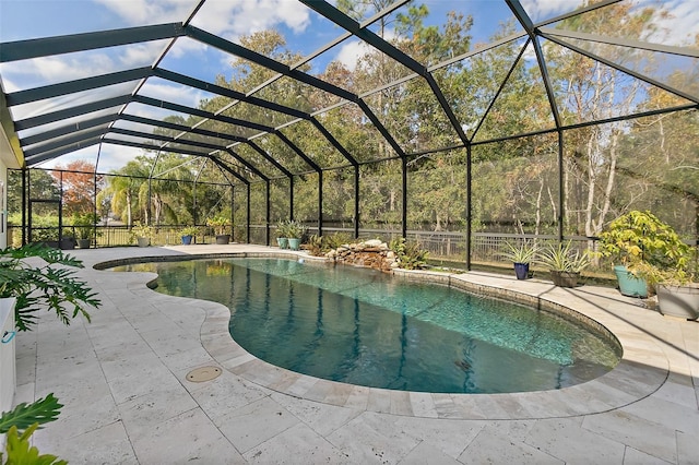 view of swimming pool featuring glass enclosure and a patio area