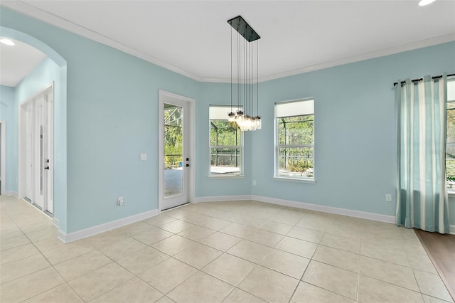 tiled spare room with a notable chandelier and crown molding