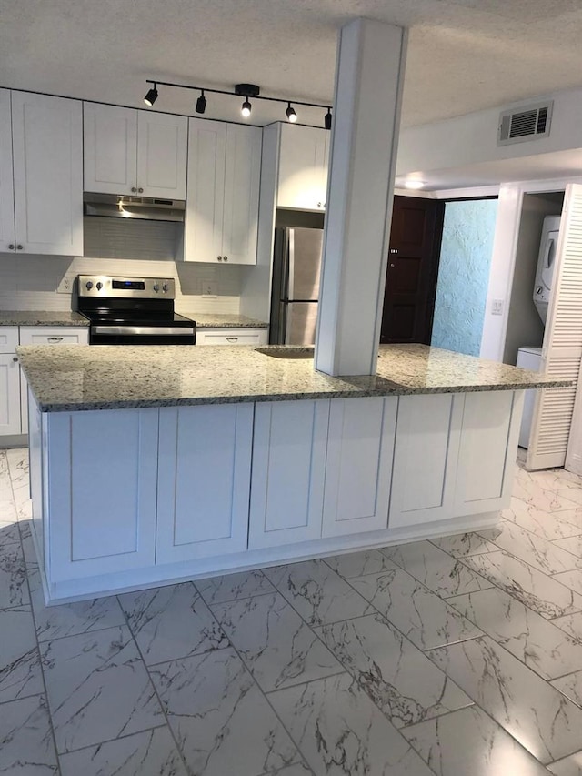 kitchen with track lighting, a textured ceiling, light stone counters, white cabinetry, and stainless steel appliances