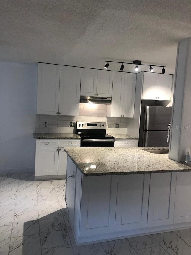 kitchen featuring stainless steel appliances, white cabinetry, stone countertops, and tasteful backsplash