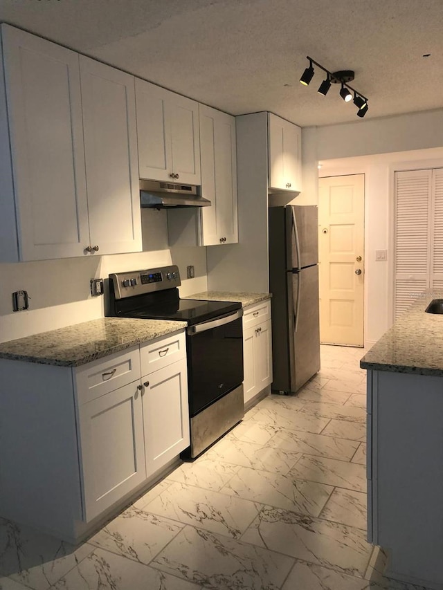 kitchen featuring light stone countertops, a textured ceiling, stainless steel appliances, and white cabinets