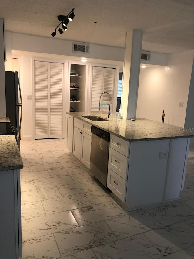 kitchen with stone counters, sink, stainless steel dishwasher, a textured ceiling, and white cabinets