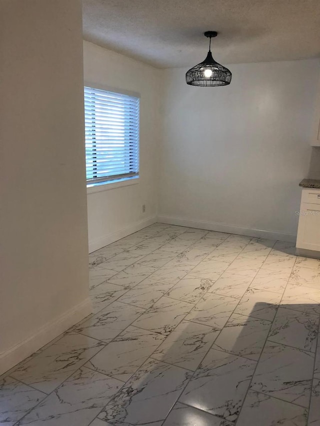 unfurnished dining area with a textured ceiling