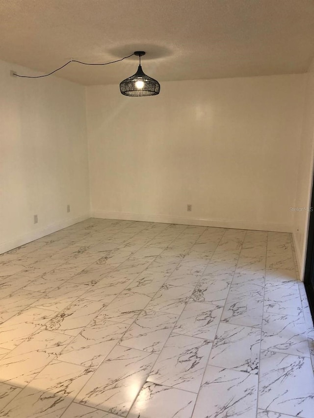 unfurnished room with a textured ceiling