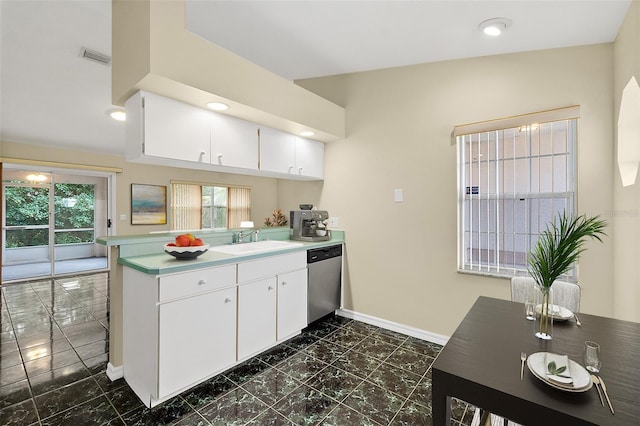 kitchen with white cabinetry, kitchen peninsula, stainless steel dishwasher, and sink