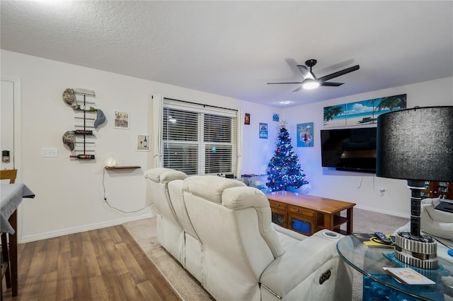 living room with hardwood / wood-style floors, a textured ceiling, and ceiling fan