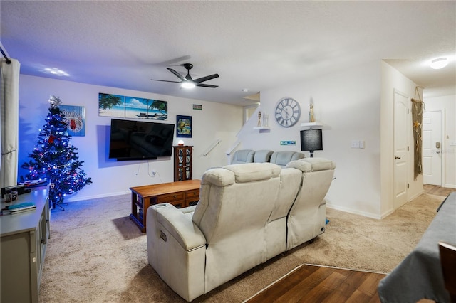 living room with ceiling fan, light hardwood / wood-style floors, and a textured ceiling