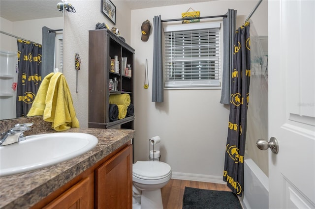 full bathroom with hardwood / wood-style floors, shower / bath combination with curtain, a textured ceiling, toilet, and vanity