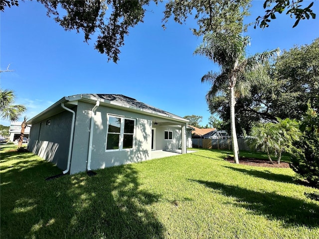 rear view of property with a lawn and a patio