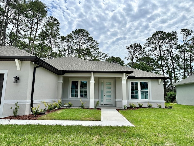 view of front of property featuring a front lawn, stucco siding, and a shingled roof