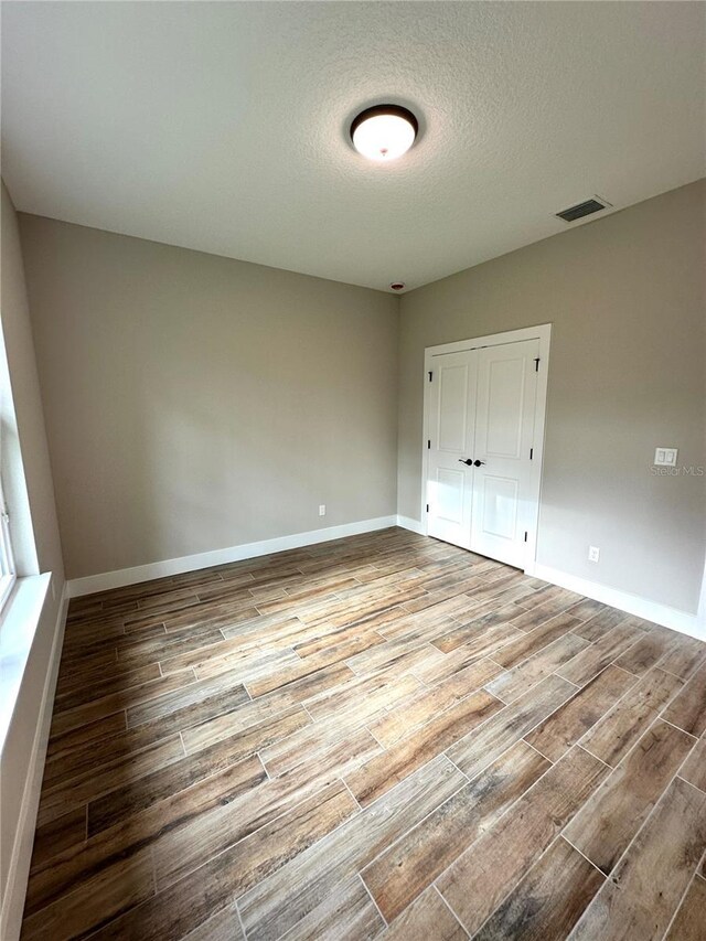 6 Lake Pl, Palm Coast, FL 32137 - unfurnished bedroom featuring wood finished floors, a closet, baseboards, and a textured ceiling