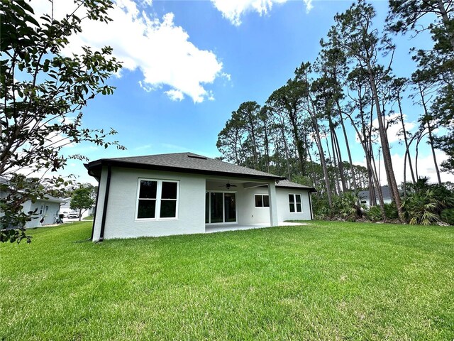 6 Lake Pl, Palm Coast, FL 32137 - back of property featuring a ceiling fan, a yard, stucco siding, and a patio