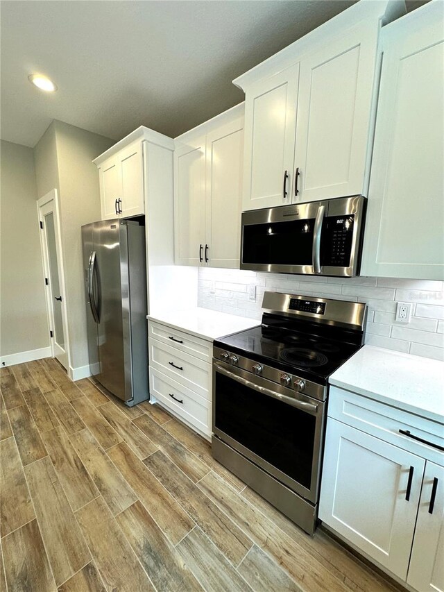 6 Lake Pl, Palm Coast, FL 32137 - kitchen featuring appliances with stainless steel finishes, light wood-type flooring, recessed lighting, backsplash, and light countertops