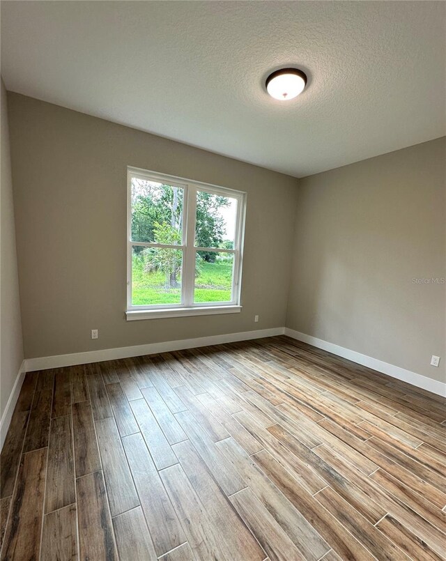 6 Lake Pl, Palm Coast, FL 32137 - empty room featuring wood finished floors, baseboards, and a textured ceiling