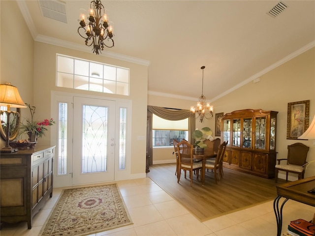 foyer entrance with light wood-type flooring, high vaulted ceiling, an inviting chandelier, and crown molding