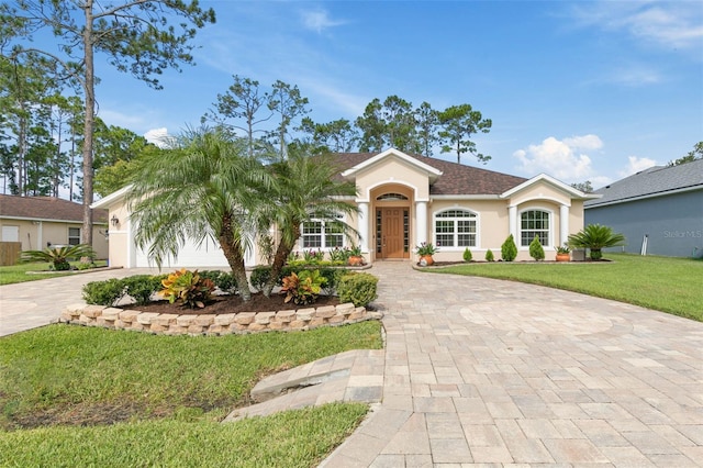 view of front of home with a front yard and a garage